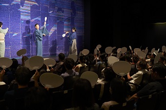 会場内で団扇を使ったレクチャーを体験する観客
