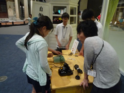 電話の使い方を説明する学芸員の画像