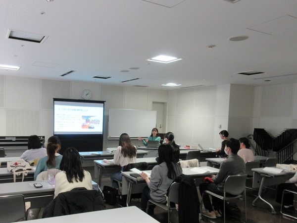 説明会に参加する学生にモニターを使ってサポートスタッフについて説明をしている