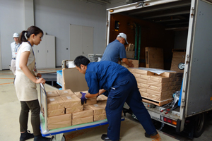 トラックから降ろされるニュースの束の画像